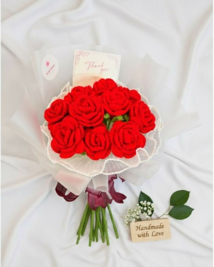 Bouquet of red artificial roses with a white ribbon on a white background