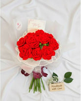 Bouquet of red artificial roses with a white ribbon on a white background