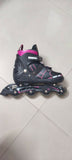 Black and pink inline skate on a light gray floor