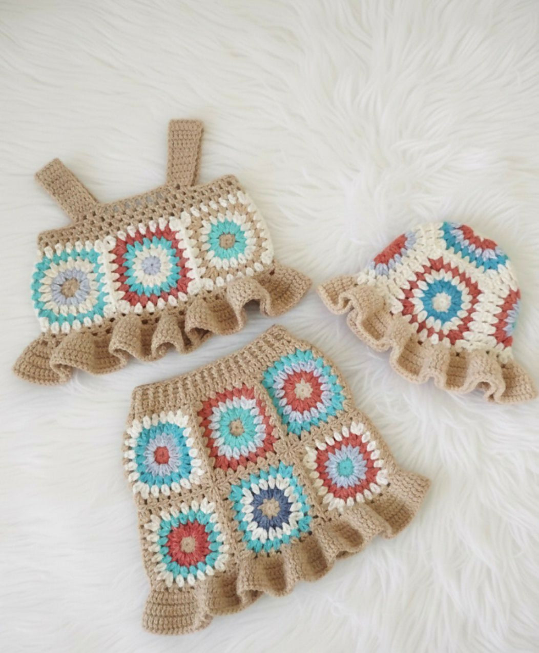 Crocheted baby outfit with colorful square patterns
