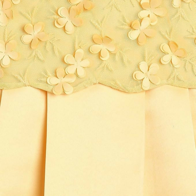 Close-up of yellow fabric with floral embroidery on a matching yellow background