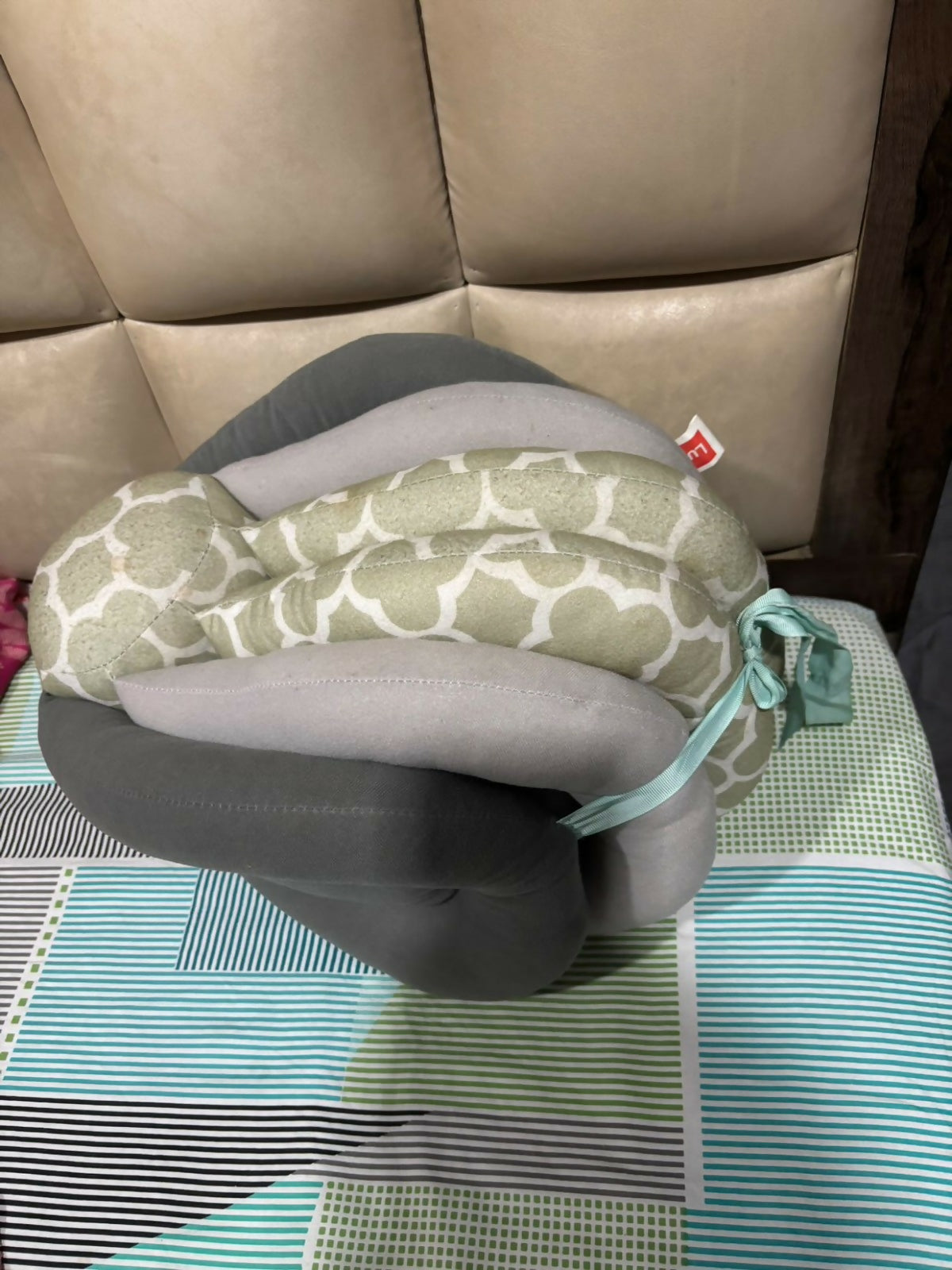 Neck pillow with patterned cover on a checkered surface