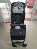 Black stroller with a visible brand logo on a tiled floor.