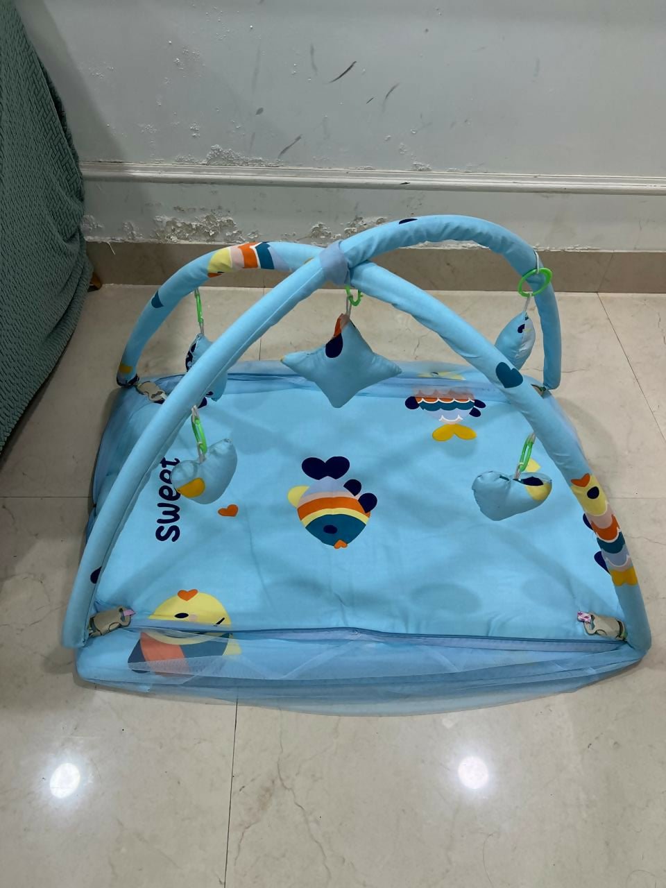 Baby bed with hanging toys featuring a soft cushioned asleeping area, protective sides, and colorful hanging toys to keep babies comfortable, engaged, and entertained.