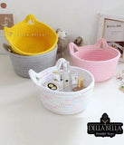 Three woven baskets in yellow, pink, and white