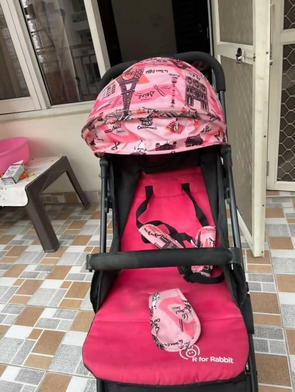 Pink and black patterned stroller on a tiled floor