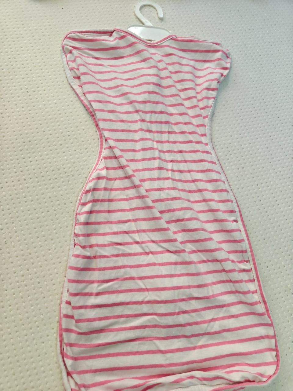 Striped dress with red and white pattern on a beige surface