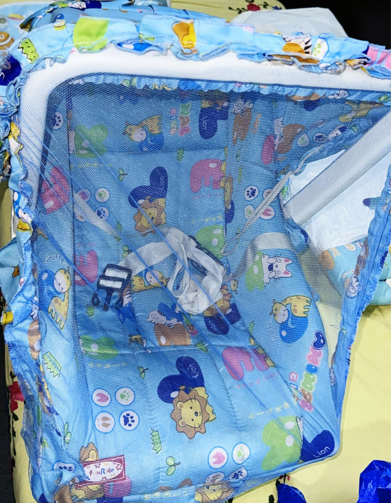 Children's playpen with cartoon animal patterns on a blue background