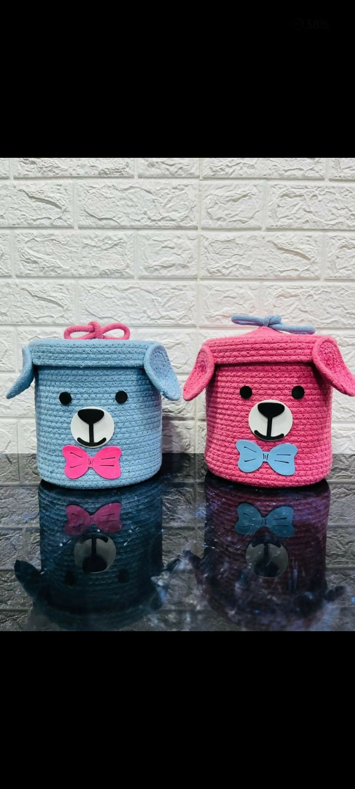 Two small storage baskets shaped like dogs, one blue and one pink