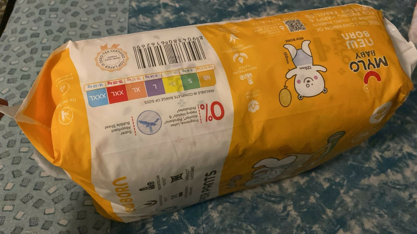 Pack of diapers with a visible brand logo on a textured surface