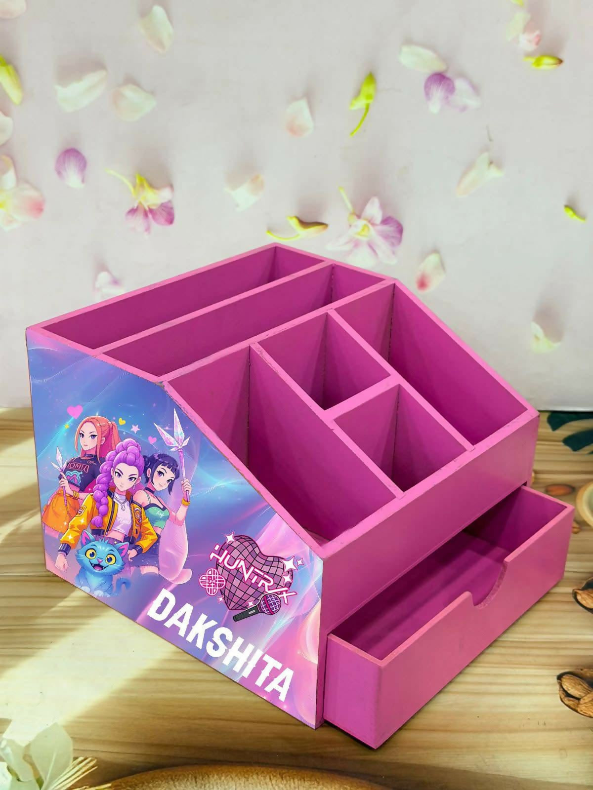 Pink desk organizer with compartments and a drawer, featuring cartoon characters
