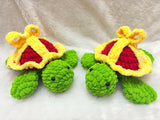Two green turtles with red hearts and yellow crowns on a white background