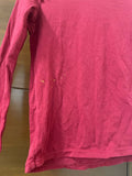 Pink long-sleeve shirt on a wooden surface
