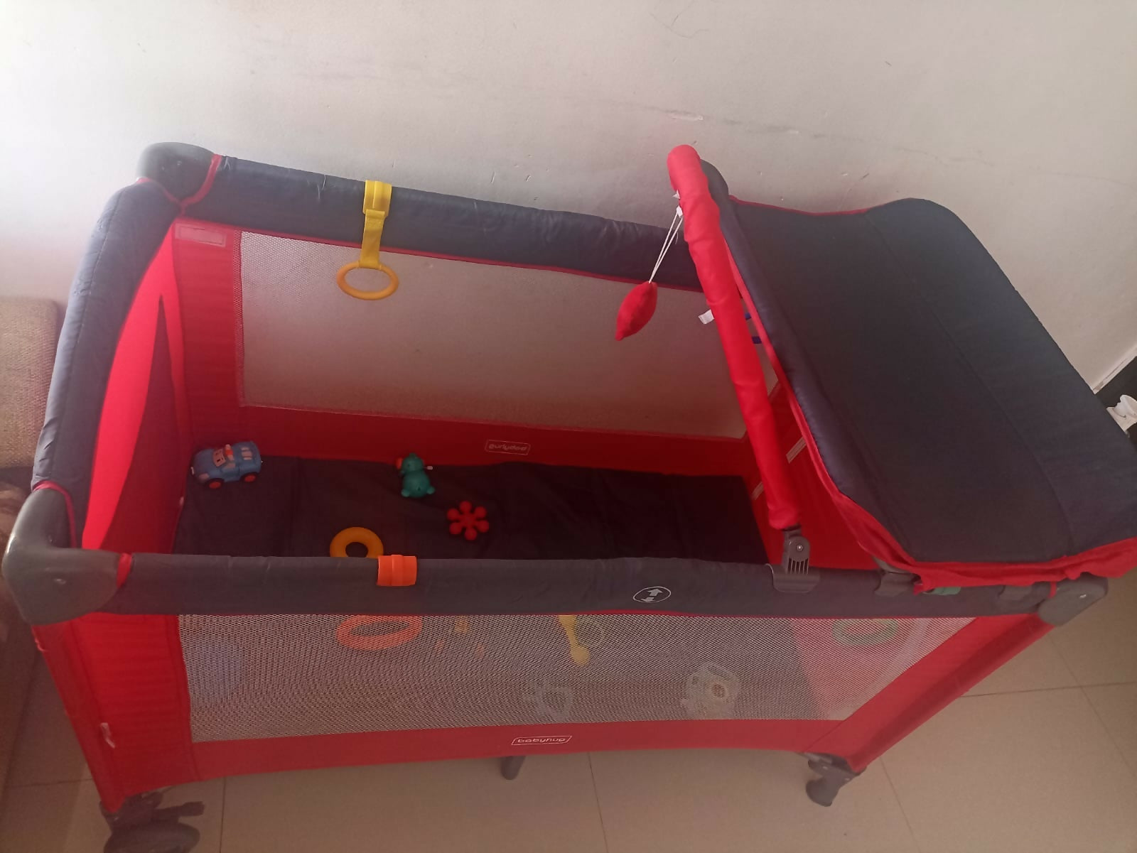 Babyhug playpen with mosquito net, helper rings, cot mobile and diaper changing table, foldable and travel-friendly, used for 7 months