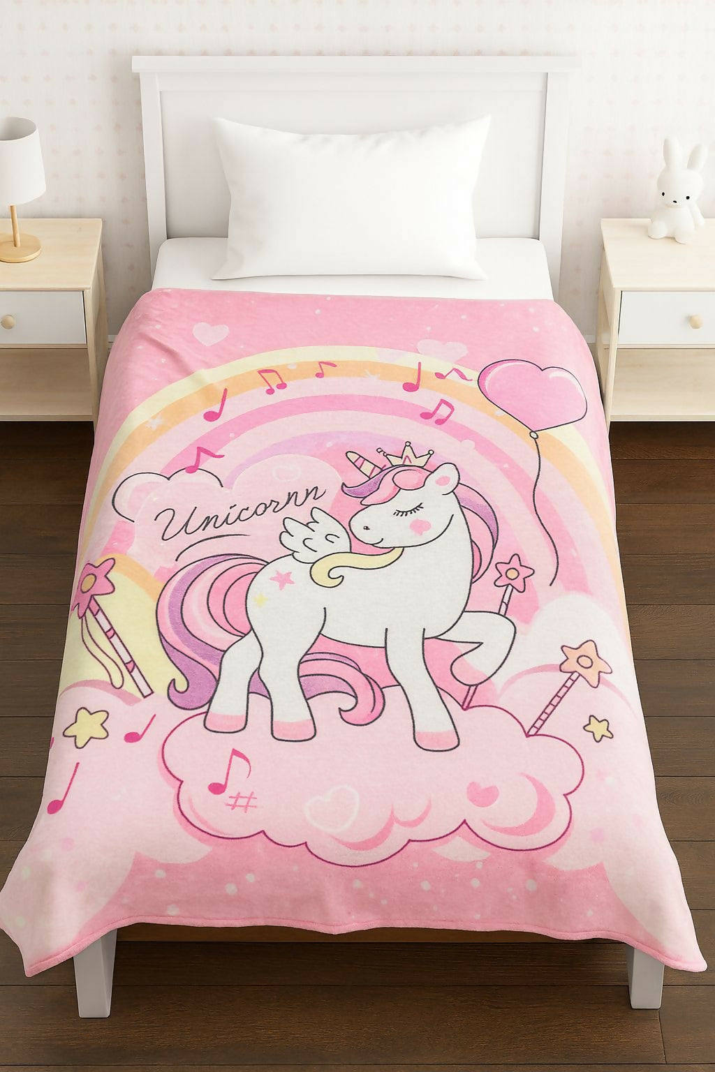Pink unicorn-themed comforter on a bed i