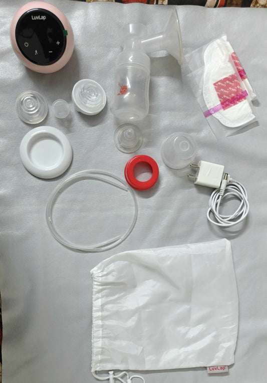 Collection of breast pump parts and accessories on a white surface