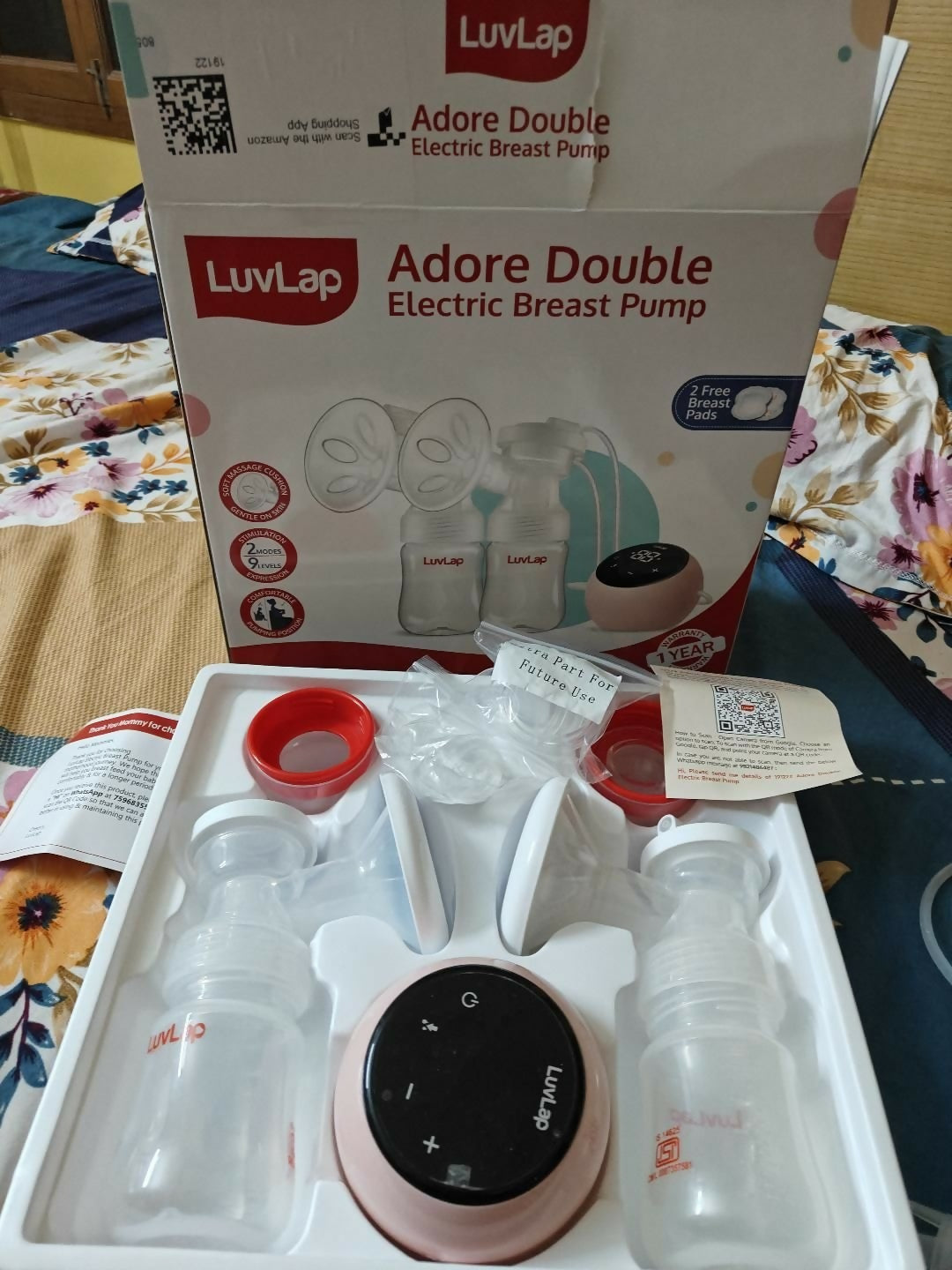 Luvlap Adore Double Electric Breast Pump with packaging on a floral bedspread
