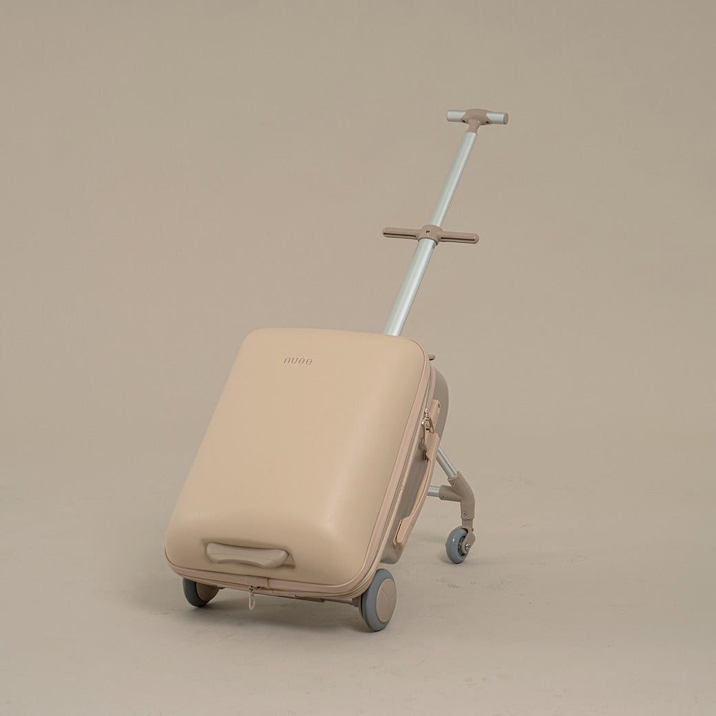 Beige suitcase with wheels and handle on a beige background