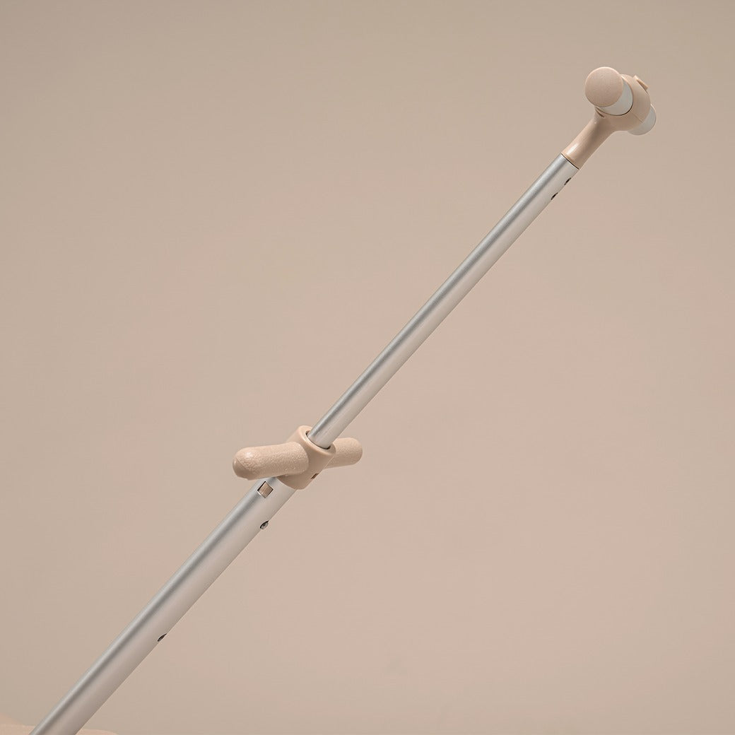 Light gray metal rod with beige rubber ends on a beige background