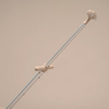 Light gray metal rod with beige rubber ends on a beige background