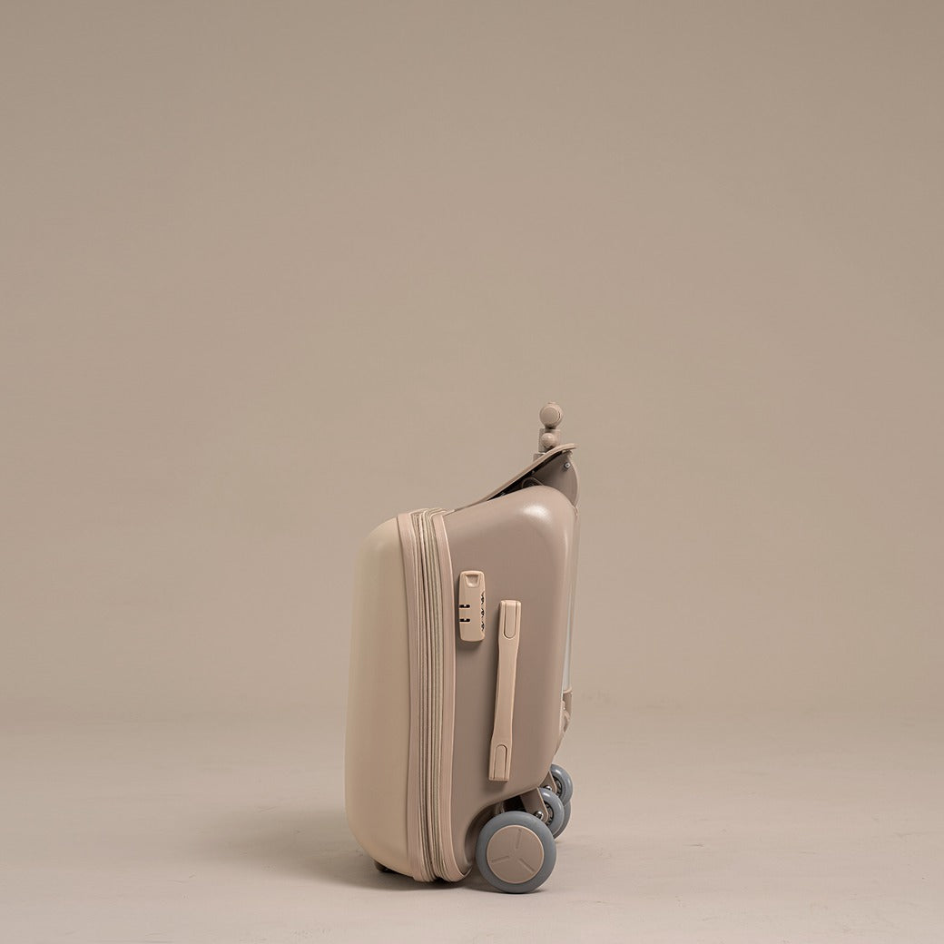 Beige suitcase with wheels on a beige background