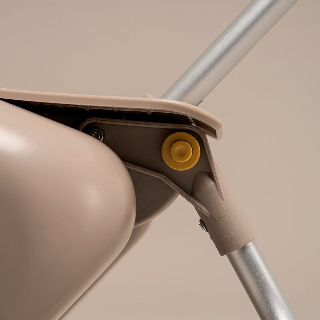 Close-up of a beige mop with a yellow wheel on a beige background