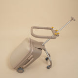 Beige suitcase with a rolling handle on a beige background