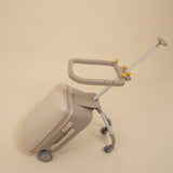 Beige suitcase with a rolling handle on a beige background