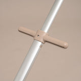 Metal rod with beige crossbar and handles on a beige background