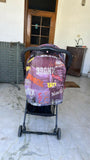 Stroller with a colorful cover on a tiled floor