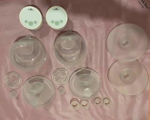 Collection of various silicone bottle caps and lids on a pink fabric background