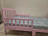 POLKA TOTS SideSnug toddler baby bed in pink with soft cushioned design, protective side bolsters, cozy sleeping space, and comfortable support for toddlers and young children.