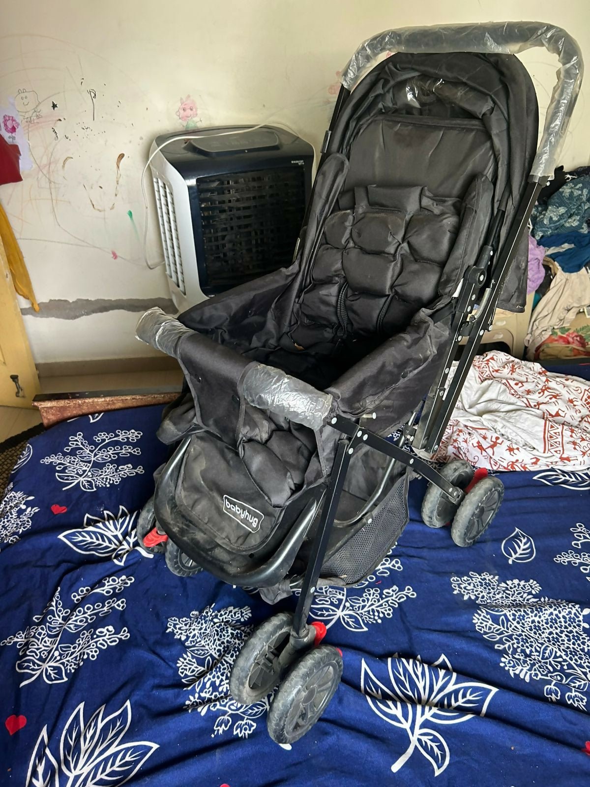 BABYHUG Cocoon stroller with mosquito net, reclining seat, safety harness, protective canopy, smooth wheels, and comfortable travel design for babies.