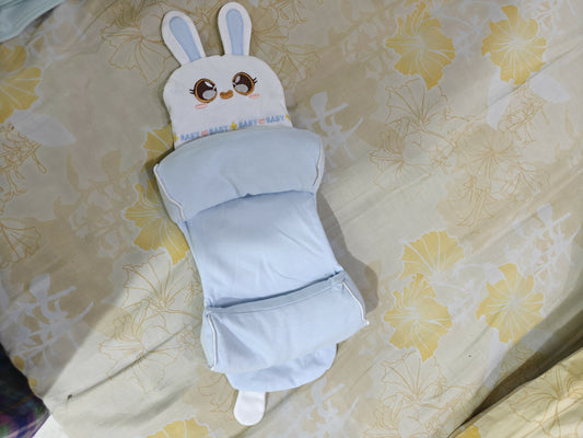 Baby pillow with cartoon face on a floral bedspread
