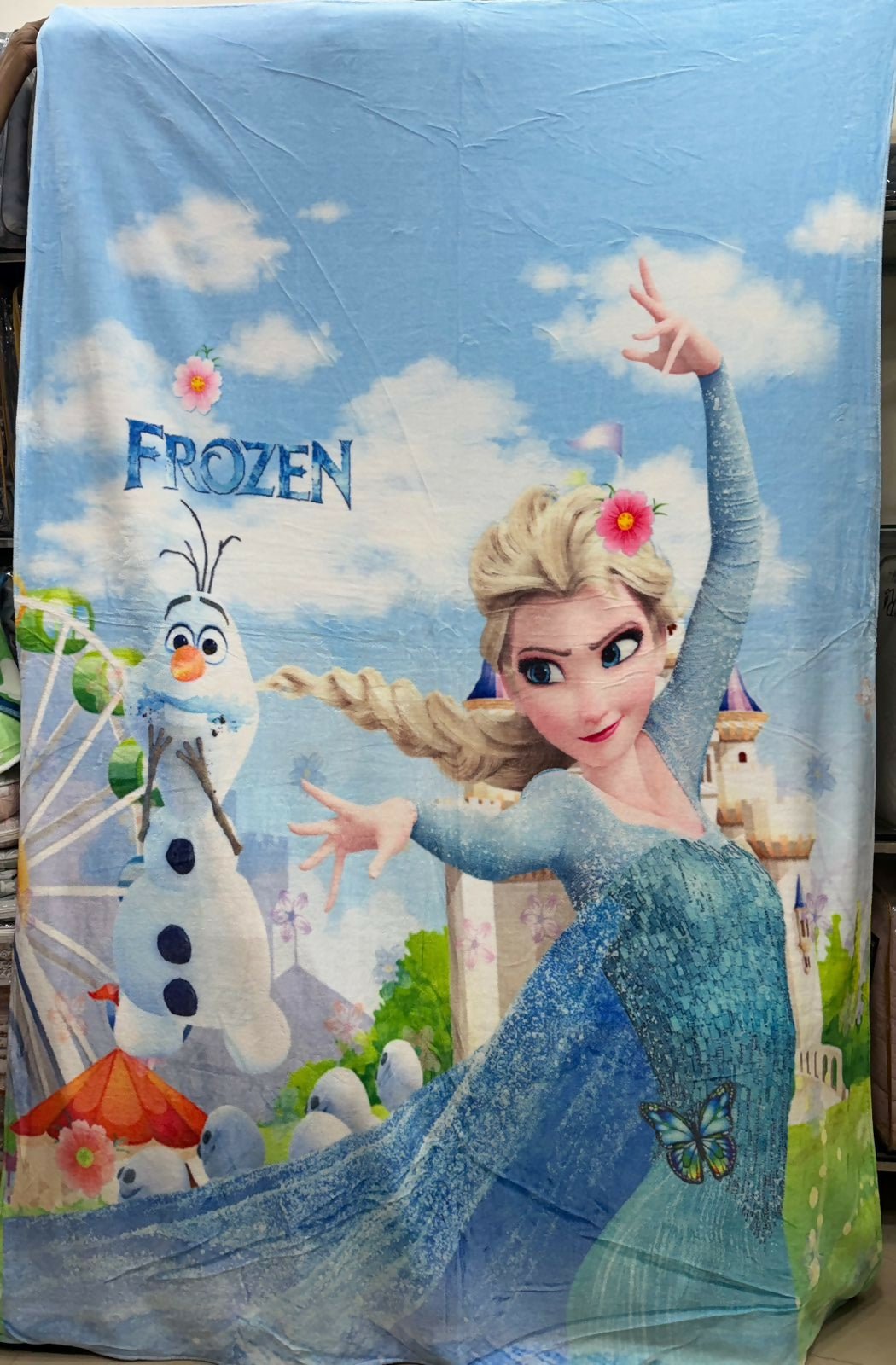 Frozen-themed blanket with Elsa and Olaf on a blue sky background