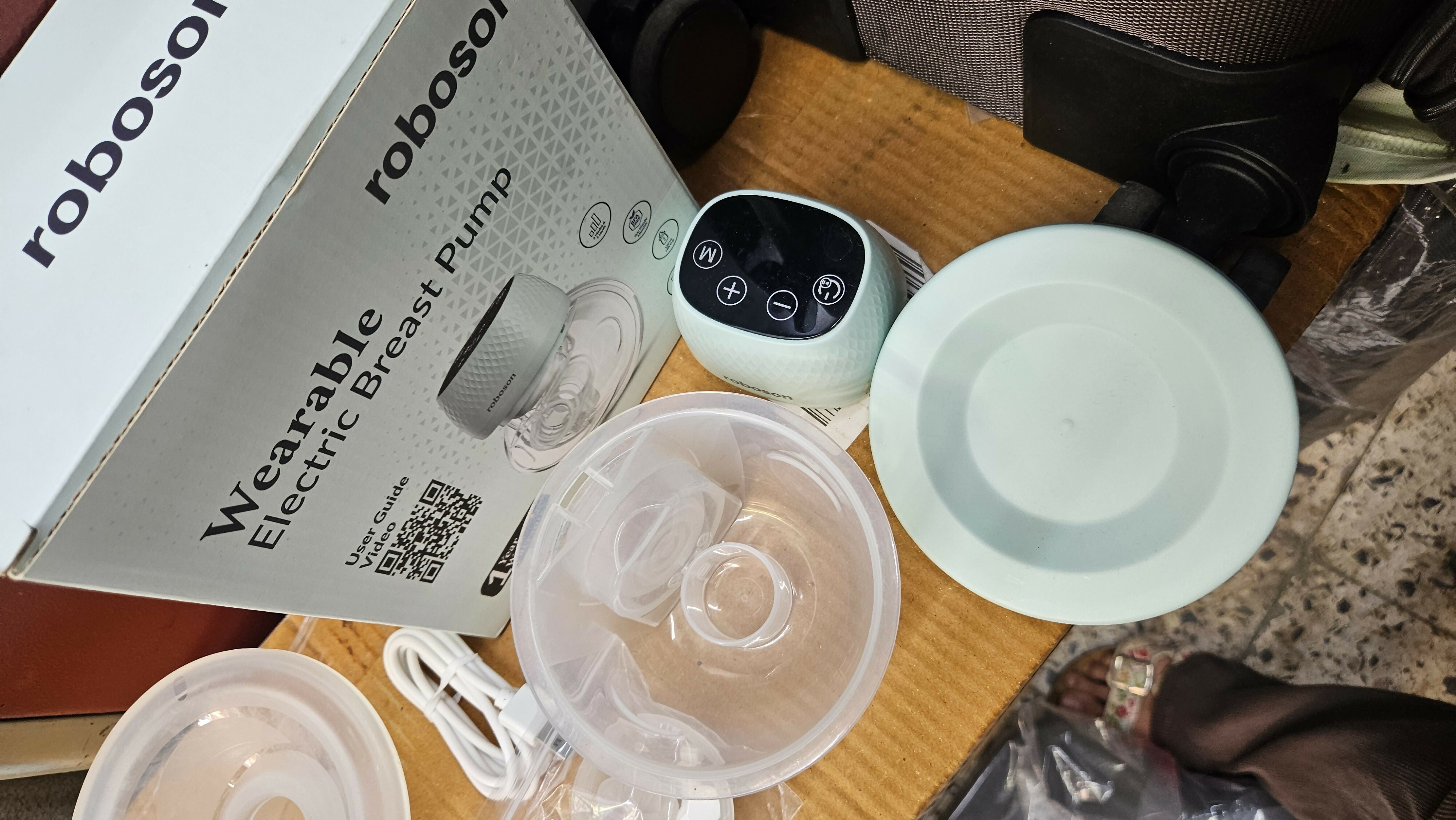 ROBOSON wearable breast pump with hands-free design, compact milk collection cups, adjustable suction settings, and portable pumping support for breastfeeding mothers.