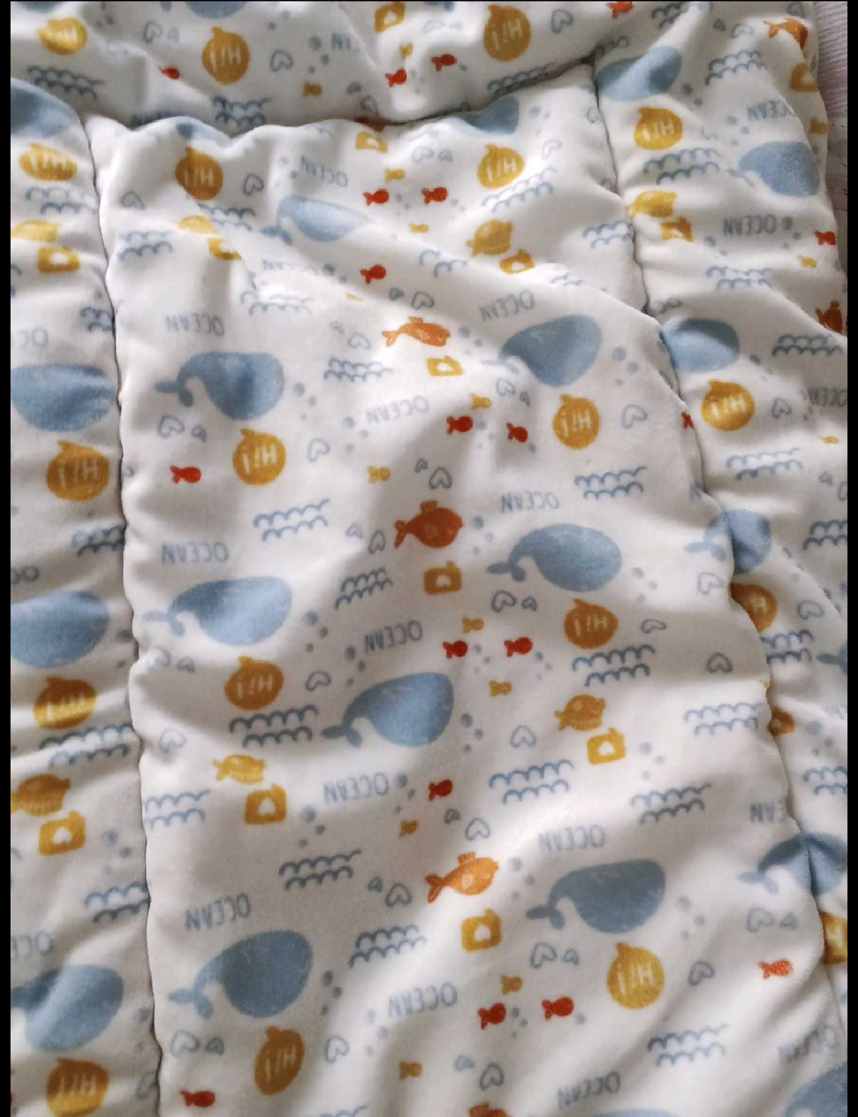 Baby blanket with colorful animal pattern on a white background