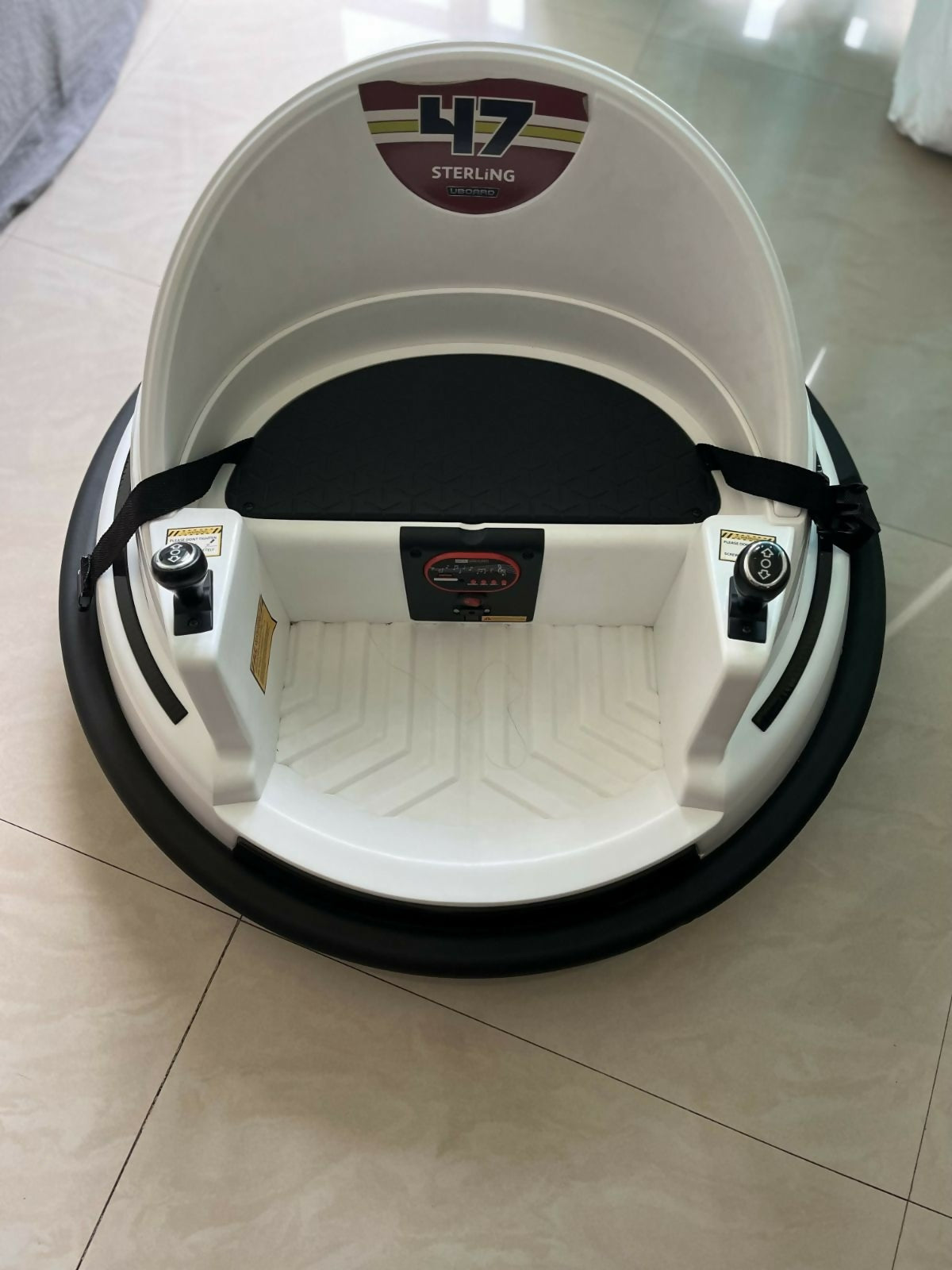 White and black hoverboard with '47 Sterling' branding on a tiled floor.