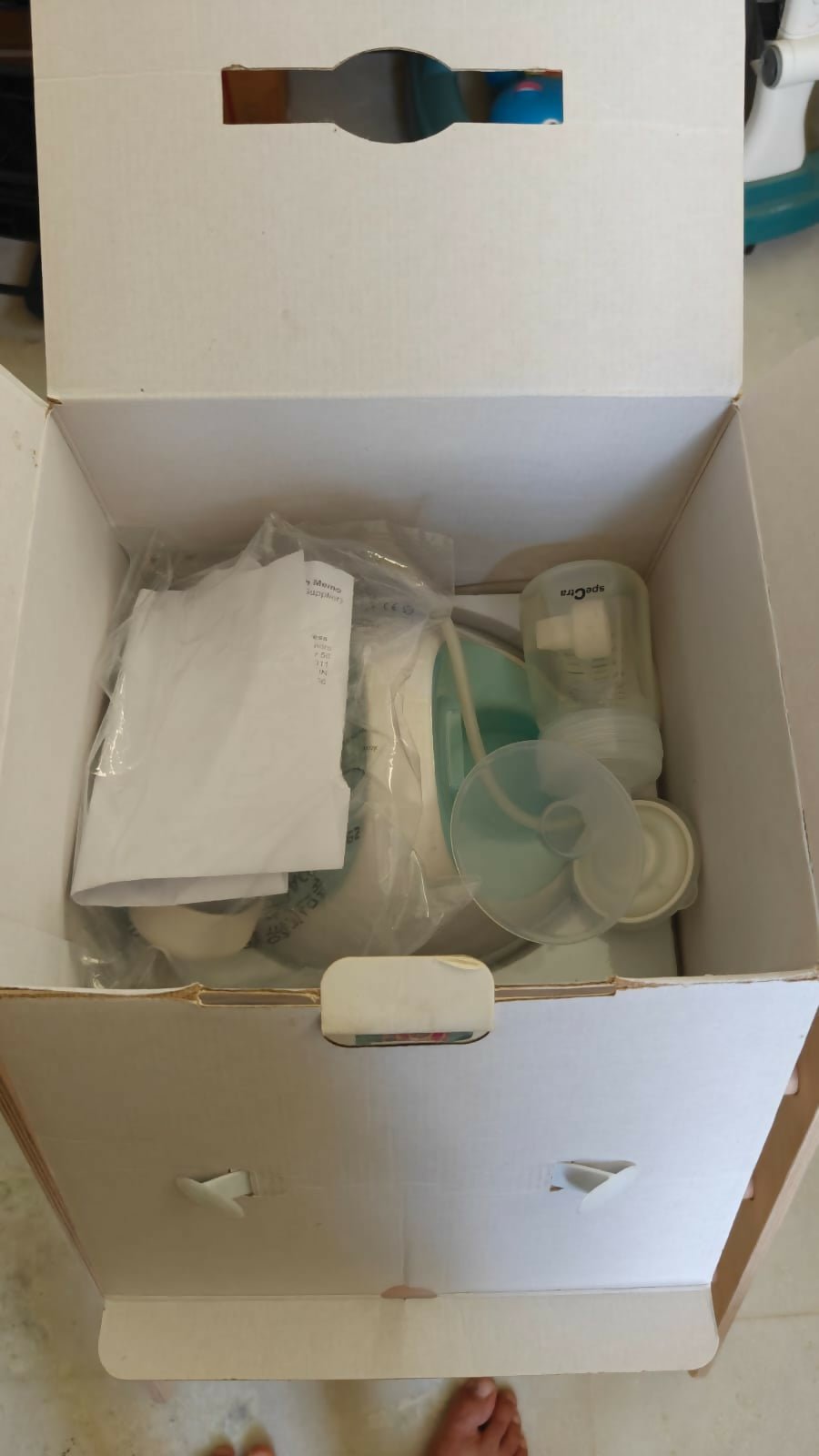 SPECTRA S-1 Plus Electric Breast Pump in White & Sky Blue with adjustable suction levels, massage mode, rechargeable battery, closed-system hygiene, and quiet operation for comfortable milk expression.