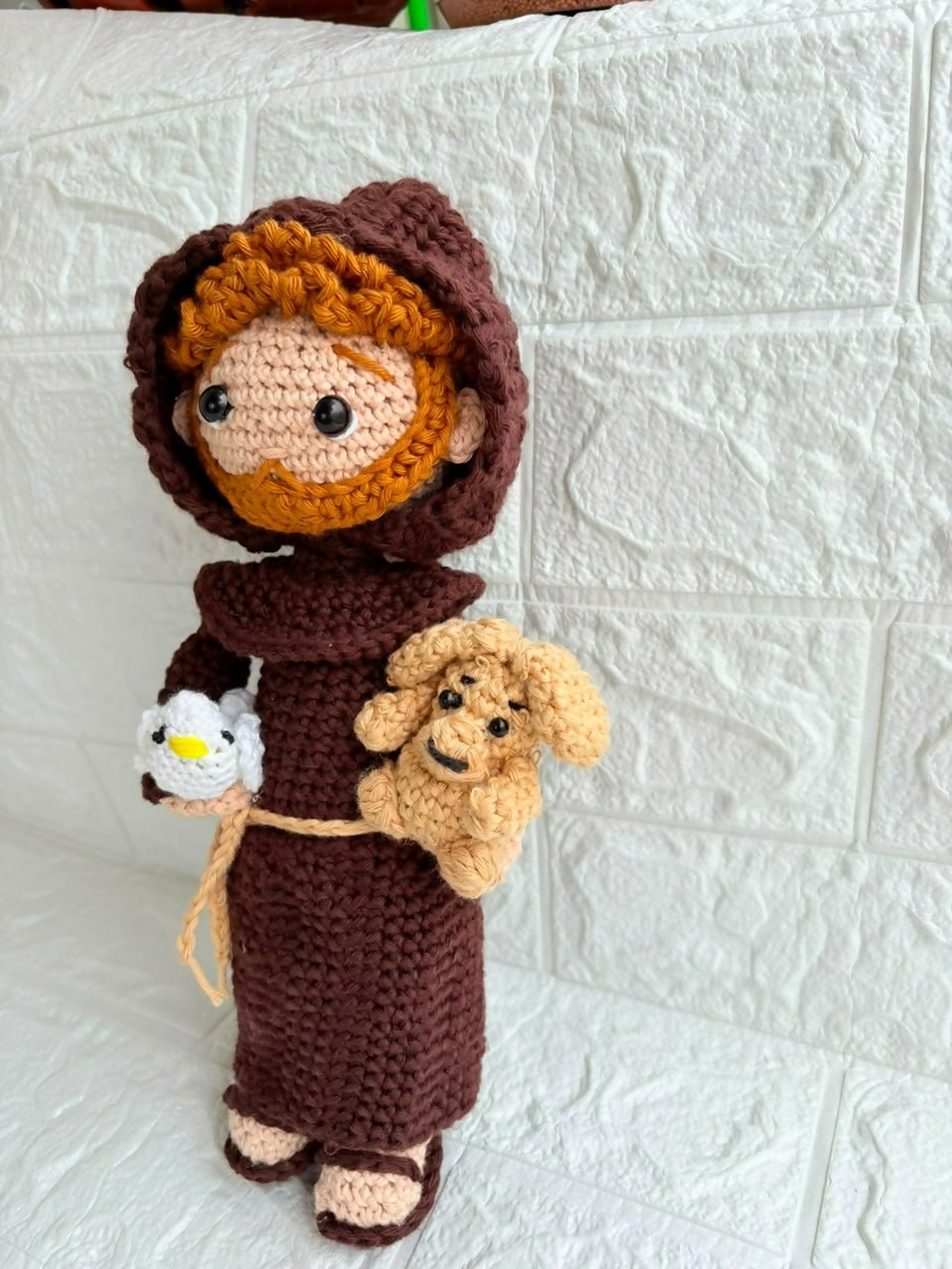 Handmade St. Francis of Assisi crochet doll crafted from soft yarn with detailed stitching, a gentle expression, and a charming design for gifting, collecting, or nursery décor.