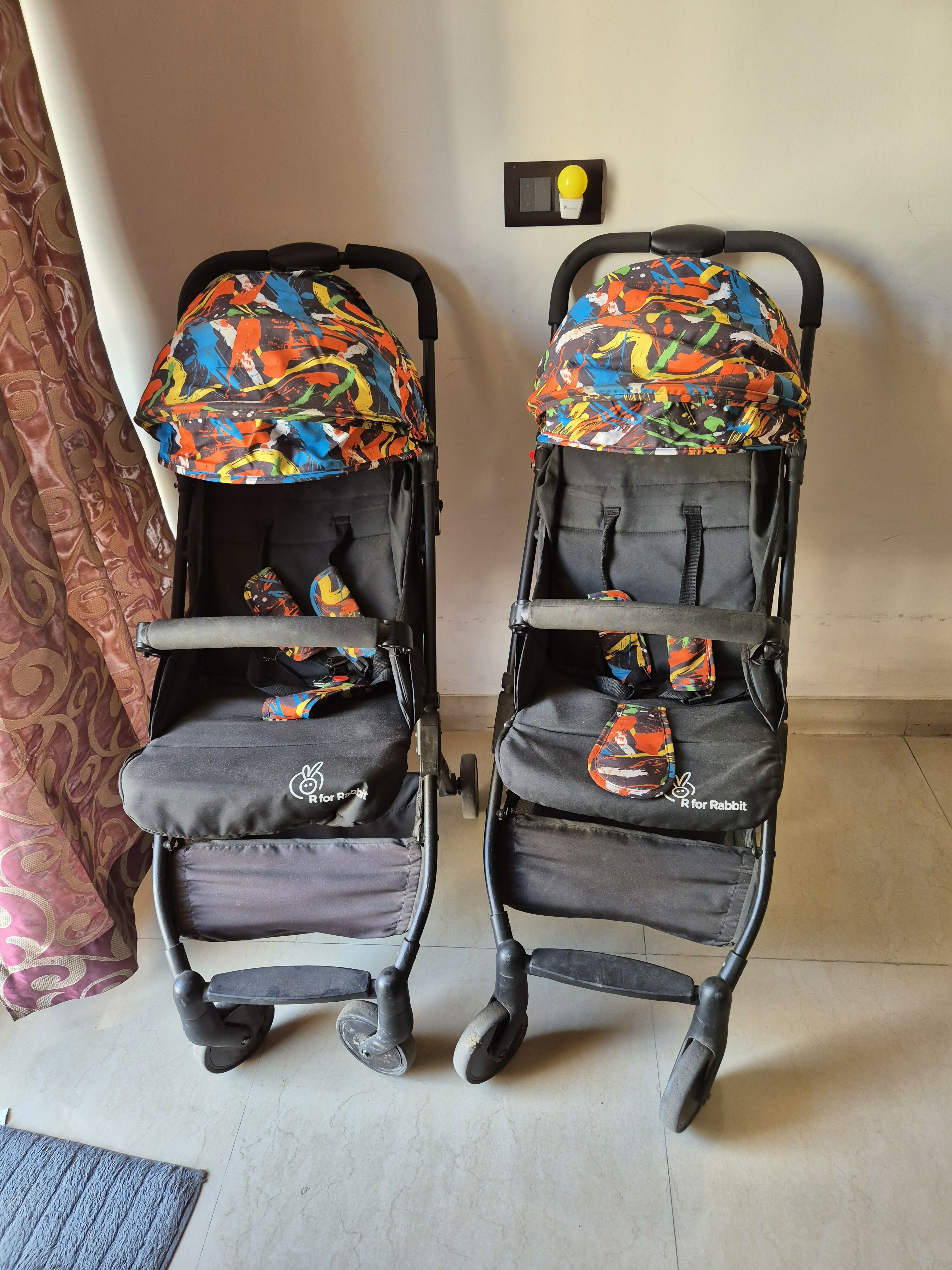 Two baby strollers with colorful seats