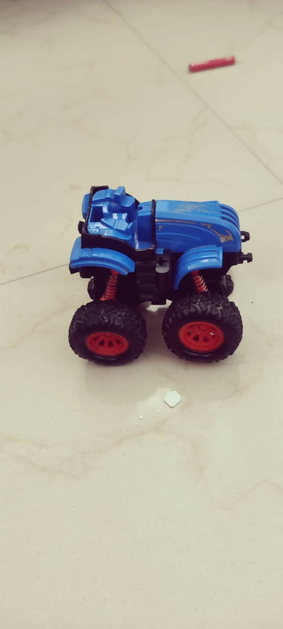 Blue toy truck with large wheels on a light-colored floor