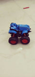 Blue toy truck with large wheels on a light-colored floor