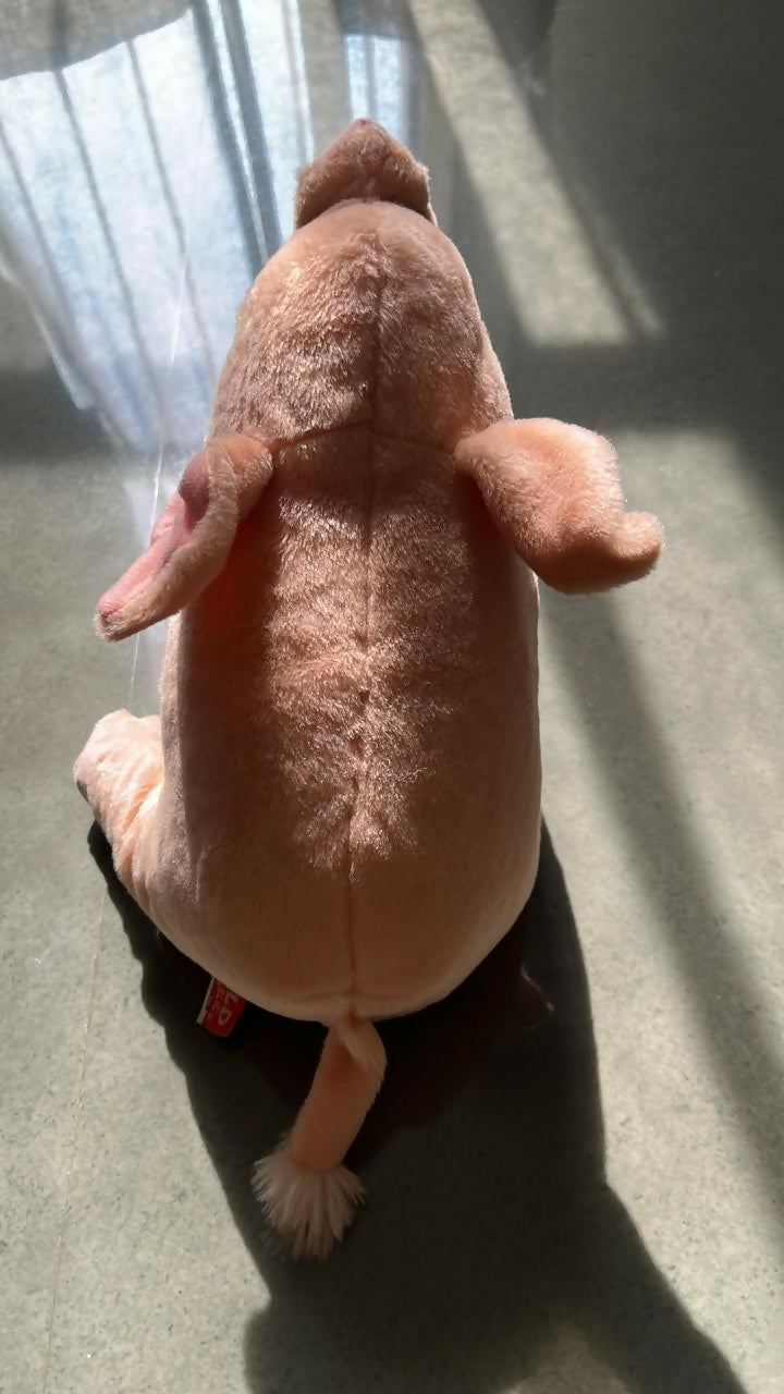 Plush toy resembling a dog on a dark surface with a light background