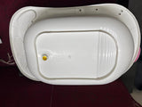 White plastic basin with a yellow dot on a dark surface