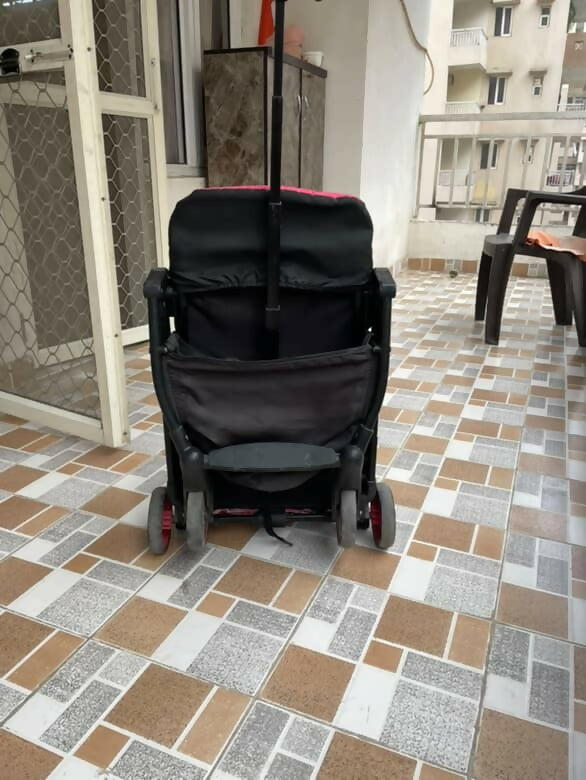 Black stroller on a tiled patio