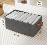 Gray storage basket with rolled-up clothes on a striped surface, featuring measurements and a brand logo.