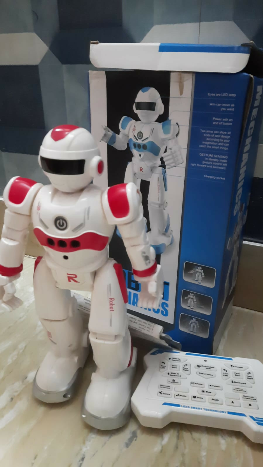 White and red robot toy with blue and white box in the background
