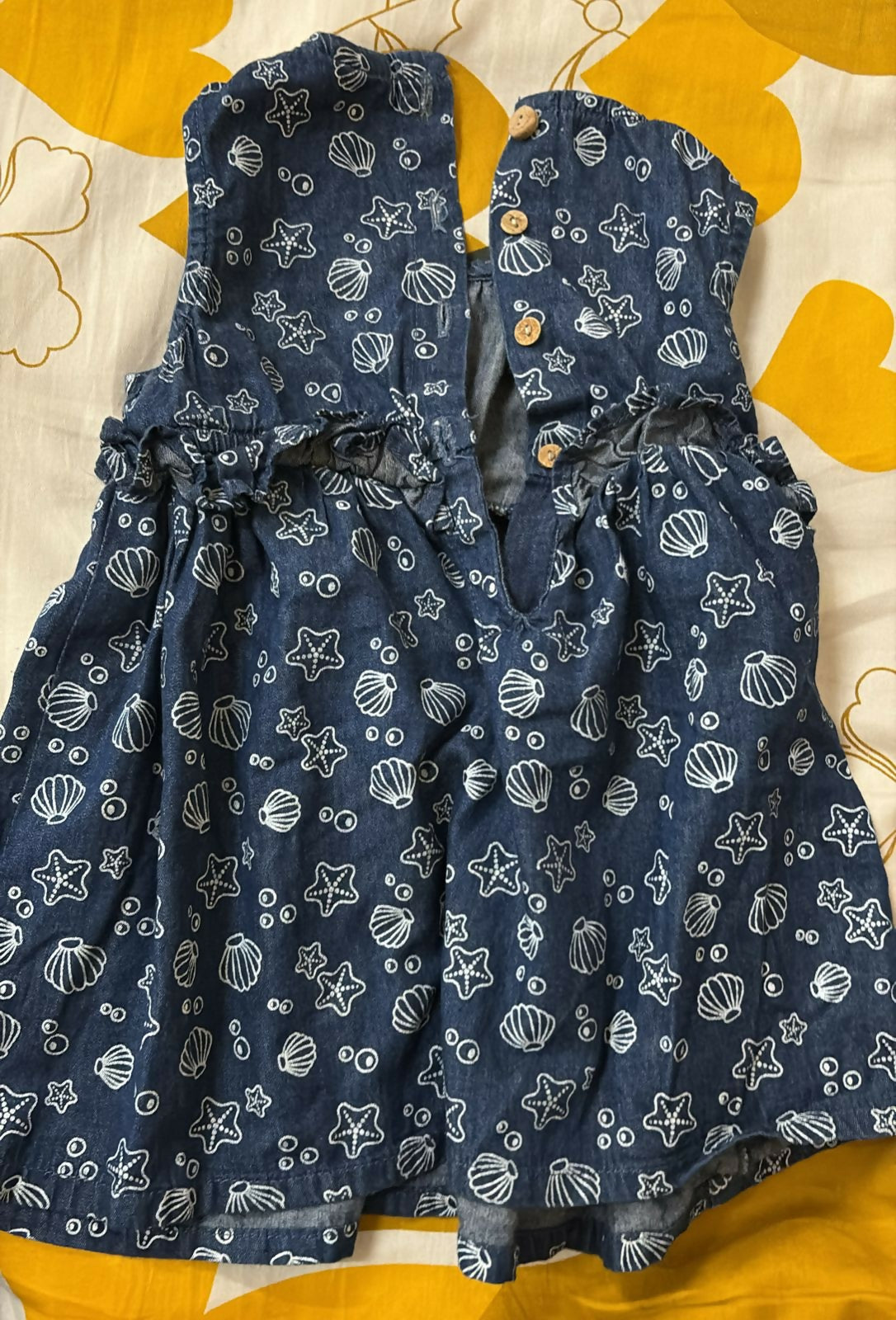 Blue dress with star and shell pattern on a yellow and white background