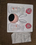 Breast pump set with bottles and accessories on a white tray, on a wooden surface.